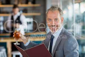 Businessman holding glass of beer and menu