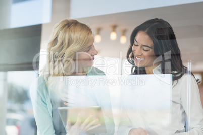 Businesswomen using digital tablet at cafÃ©