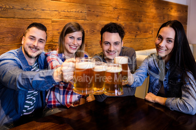 Portrait friends toasting beer at restaurant