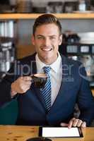 Portrait of businessman using digital tablet in cafÃ©