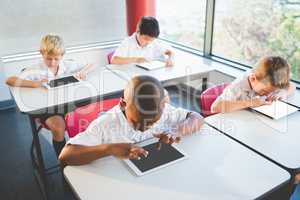 Schoolkids using digital tablets in classroom