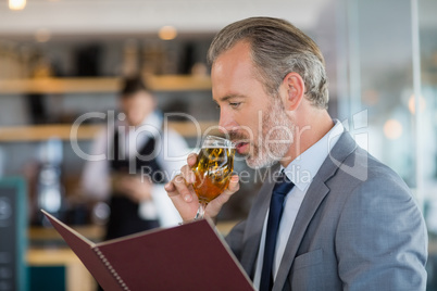 Businessman having beer and looking at menu