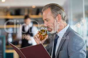 Businessman having beer and looking at menu