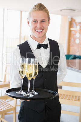 Portrait of waiter holding glasses of champagne