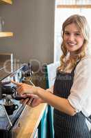 Portrait of smiling waitress making cup of coffee