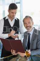 Waiter taking the order from a businessman