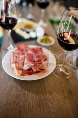 Meat and wineglass on table at bar