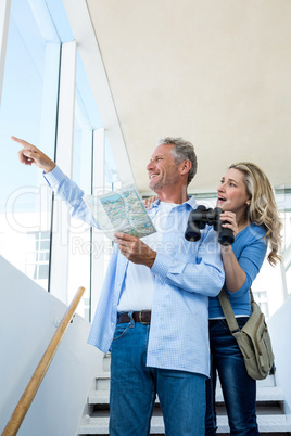 Man pointing while holding map with woman