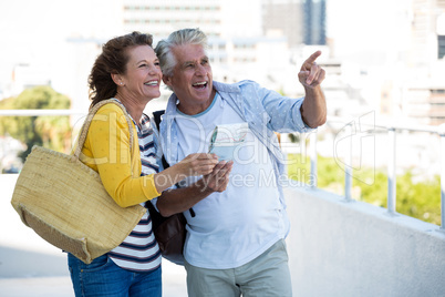 Joyful couple holding map
