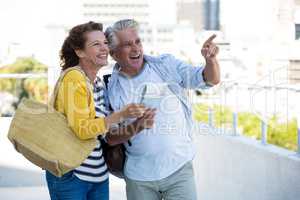 Joyful couple holding map