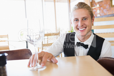 Waiter sitting at table with empty glass