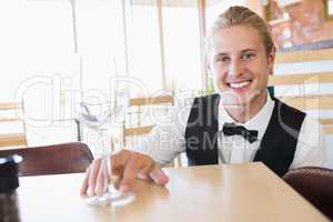 Waiter sitting at table with empty glass