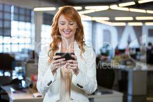 Businesswoman using cellphone while standing