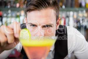 Waiter decorating cocktail with lime