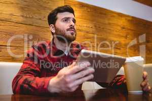 Young man using digital tablet in restaurant