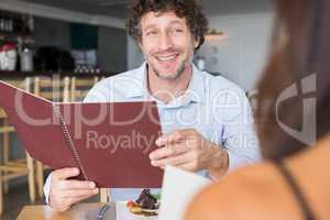 Man holding menu card and smiling