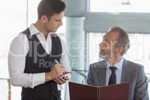Waiter taking the order from a businessman