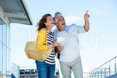 Joyful couple looking away against sky