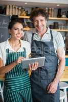 Portrait of waiter and waitress holding digital tablet