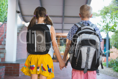 Rear view of schoolkids standing in corridor