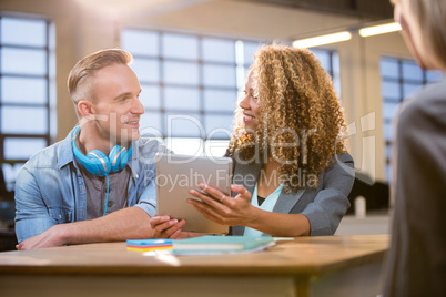 Colleagues smiling while discussing at desk