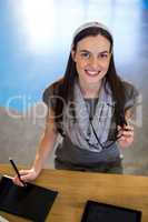 Businesswoman working on graphics tablet in office