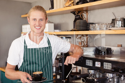 Waiter holding a cup of coffee