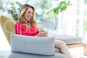 Woman using mobile phone on couch