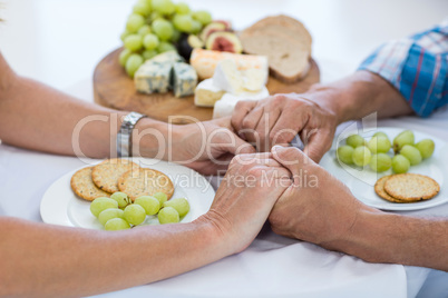 Couple holding hands while having food