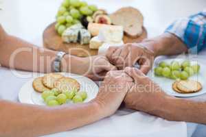 Couple holding hands while having food