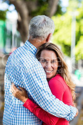 Mature woman hugging man by tree