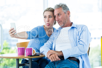 Mature couple taking selfie at home