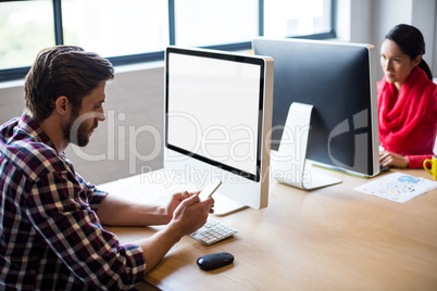 Young colleagues working at desk in office