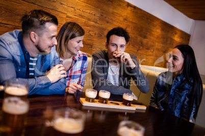 Friends having beer at table in restaurant