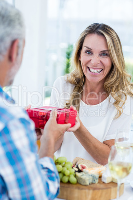 Mature woman receiving gift from husband