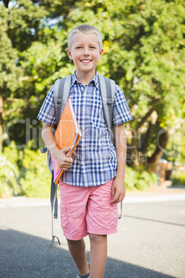 Happy schoolboy walking in campus