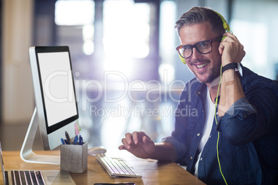 Portrait of smiling man with headphones in office