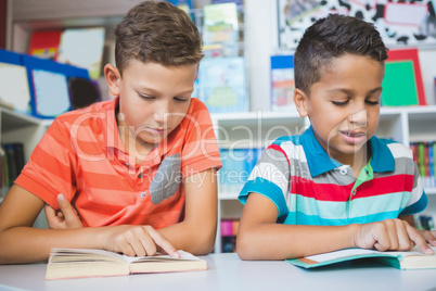 Schoolkids reading book in library