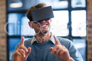 Businessman gesturing while using virtual reality headset