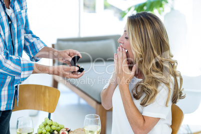 Man giving ring to woman in restaurant