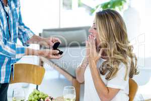 Man giving ring to woman in restaurant