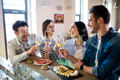 Young friends enjoying wine and food at counter