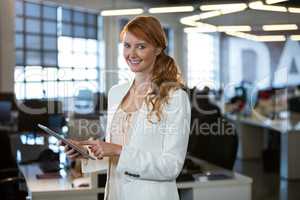 Pretty smiling businesswoman using digital tablet