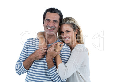 Mid adult romantic couple embracing against white background
