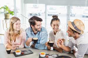 Group of happy friends having cup of coffee