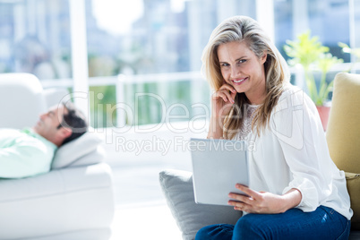 Smiling woman holding digital tablet at home