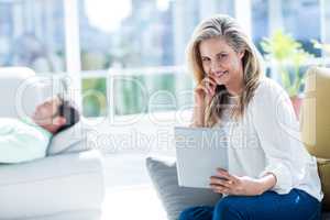 Smiling woman holding digital tablet at home