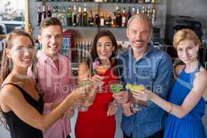 Group of friends toasting glasses of cocktail