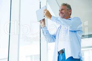 Low angle view of happy mature man holding tablet