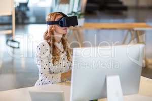 Businesswoman using virtual reality headset in office